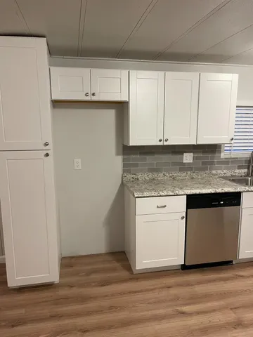a kitchen with granite countertop cabinets and wooden floor