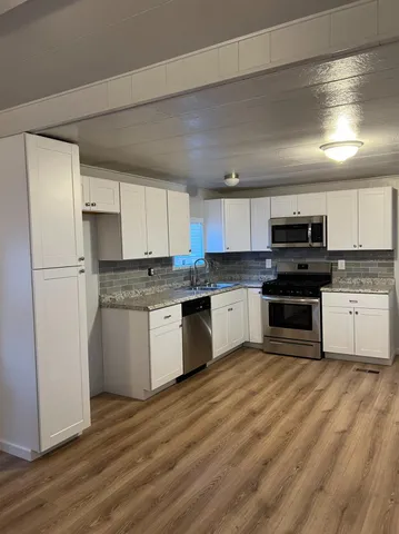 a kitchen with a refrigerator a sink and a stove top oven