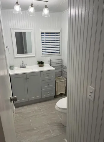 a bathroom with a toilet sink and mirror
