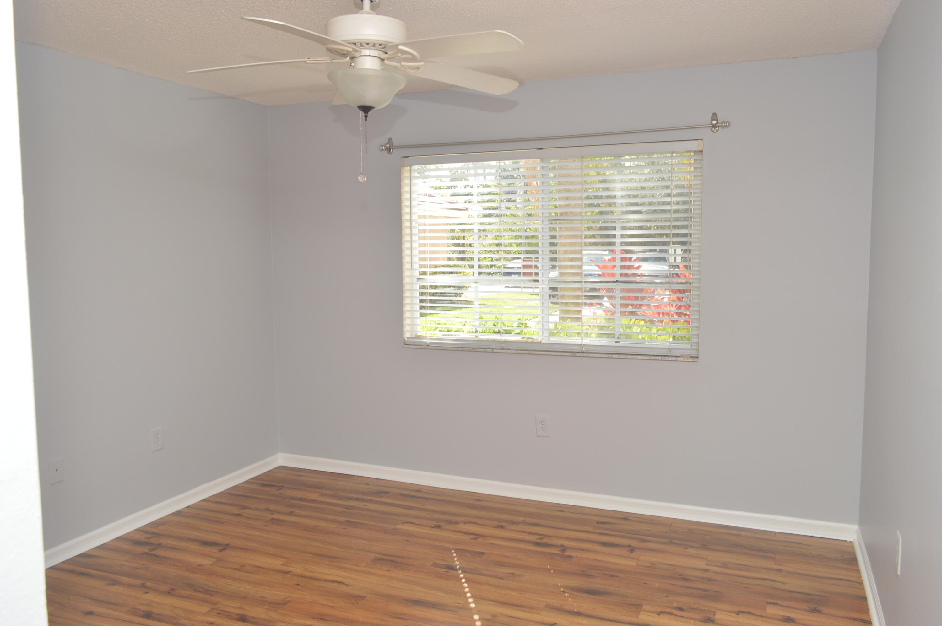 3602 Northwest Adriatic Lane, Unit 6105 Jensen Beach, FL 34957 - Photo 11 of 18 an empty room with wooden floor and windows