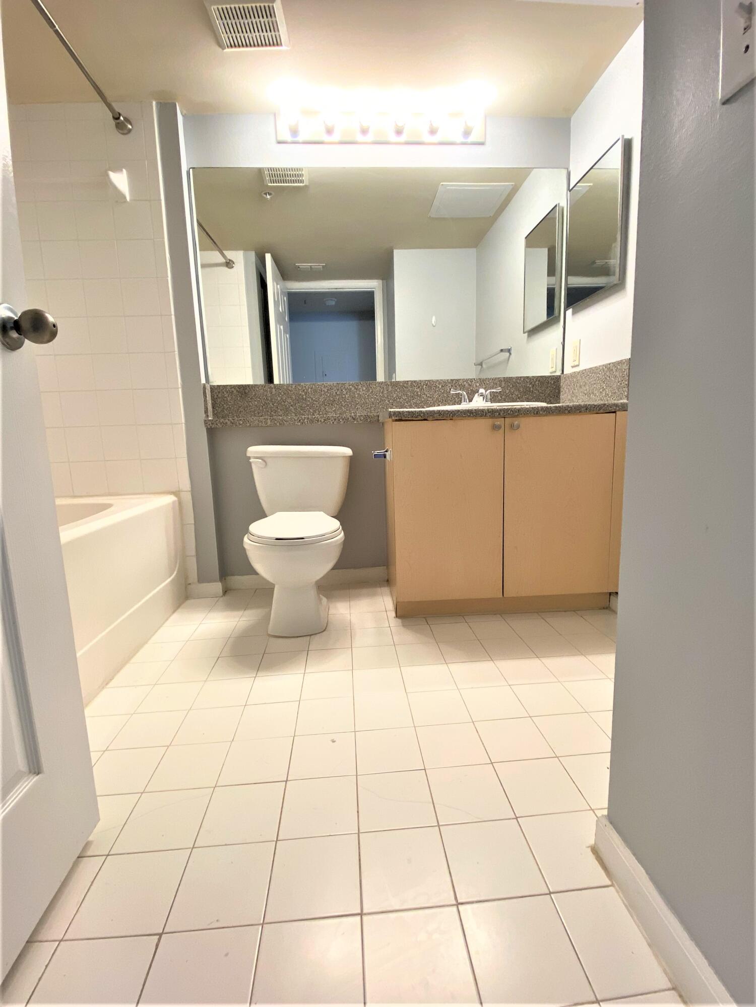 3602 Northwest Adriatic Lane, Unit 6105 Jensen Beach, FL 34957 - Photo 12 of 18 a bathroom with a sink a toilet and a mirror