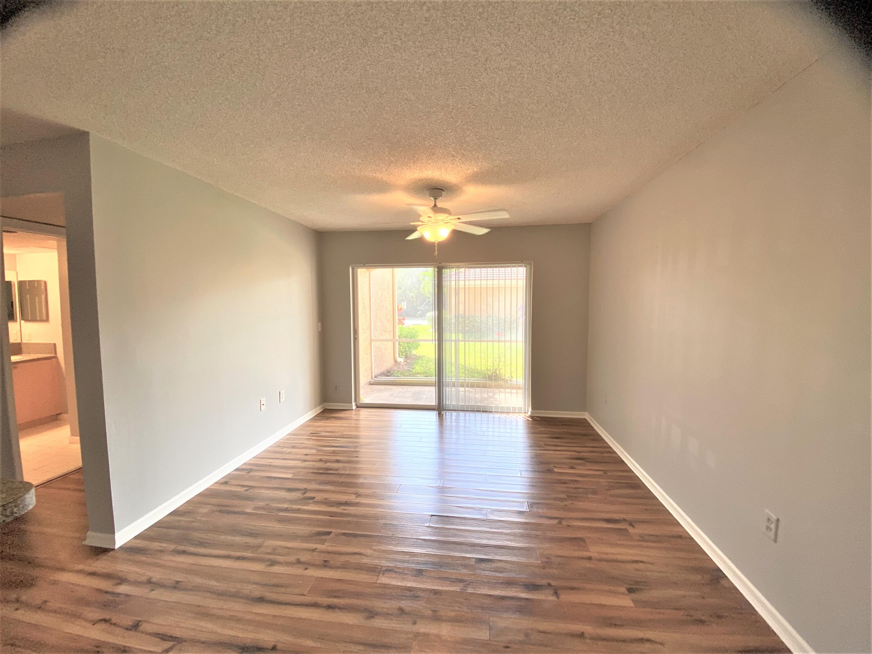 3602 Northwest Adriatic Lane, Unit 6105 Jensen Beach, FL 34957 - Photo 9 of 18 a view of an empty room with wooden floor and a window