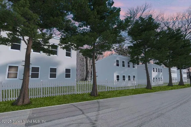 a view of a house with a small yard and large trees