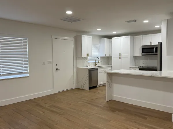 a kitchen with a sink a microwave and cabinets