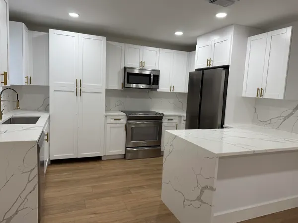 a kitchen with a sink a stove a refrigerator and a refrigerator