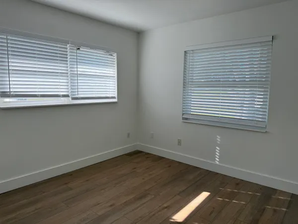 an empty room with wooden floor and a window
