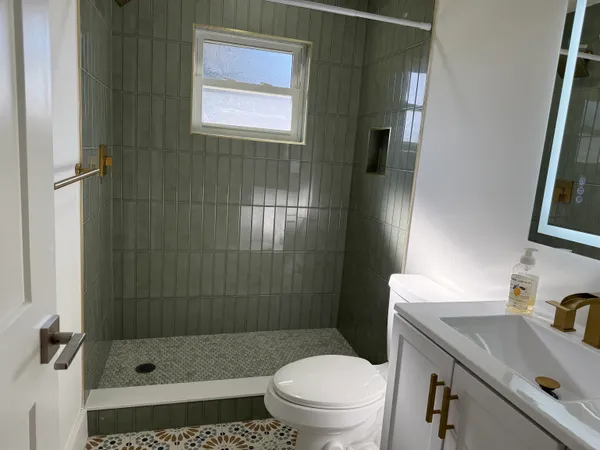 a bathroom with a sink a toilet and shower