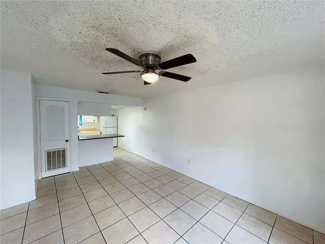 an empty room with windows and ceiling fan