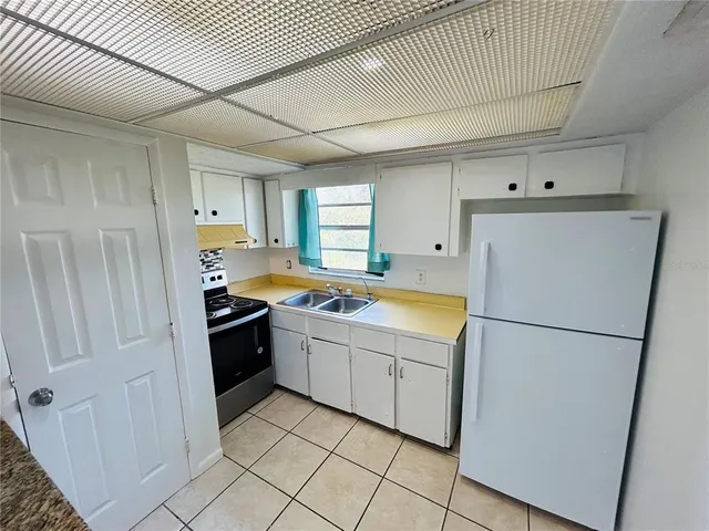 a kitchen with a refrigerator sink stove and cabinets