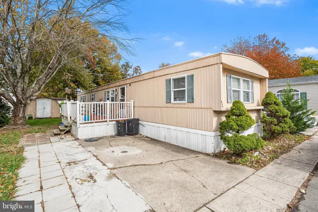 a white house that has a small yard and a large tree