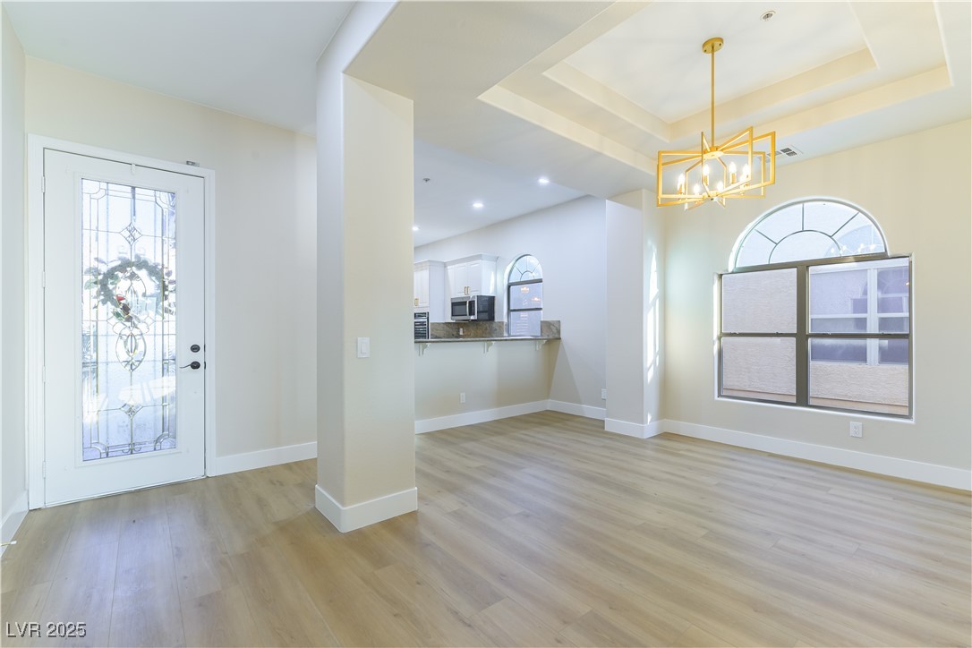 379 Marlin Cove Road Henderson, NV 89012 - Photo 9 of 22 Foyer entrance with a chandelier, light wood-style flooring, recessed lighting, and a tray ceiling