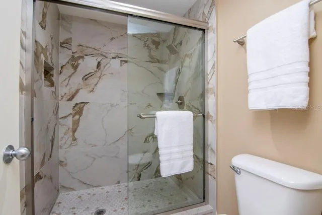 a bathroom with a granite countertop sink a toilet and bathtub
