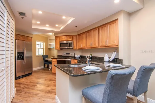 a kitchen with a dining table chairs and refrigerator