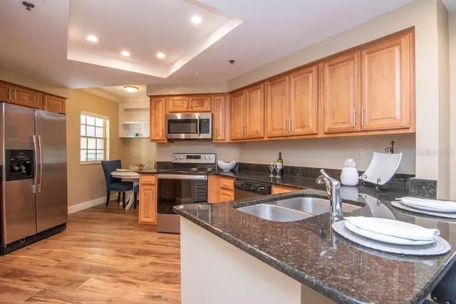 a kitchen with stainless steel appliances granite countertop a sink stove and refrigerator
