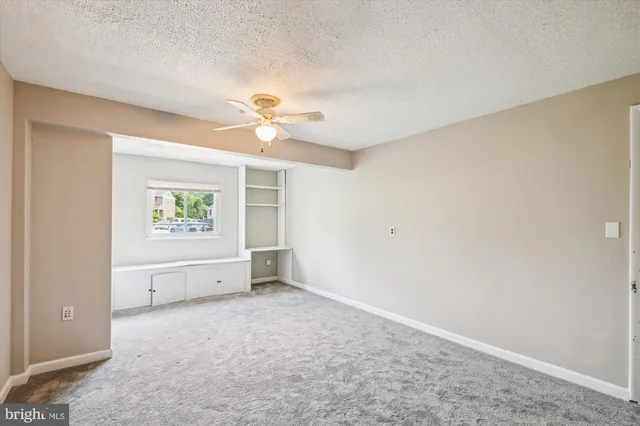 an empty room with a ceiling fan and a window