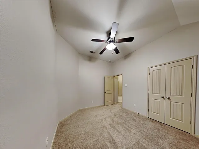 an empty room with closet and windows