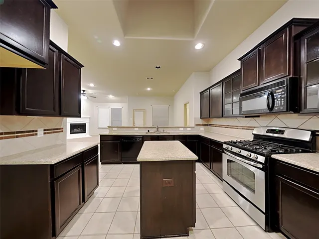 a kitchen with stainless steel appliances granite countertop a sink a stove and a refrigerator