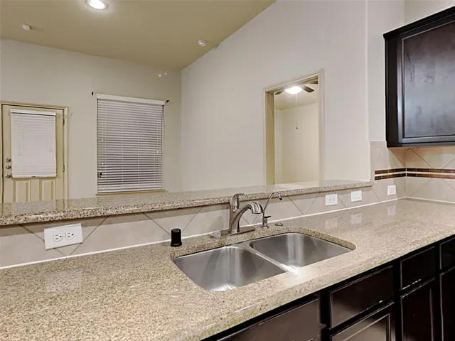 a kitchen with a sink and a large mirror