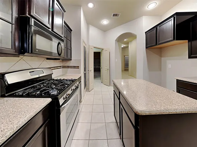 a kitchen with granite countertop stainless steel appliances and wooden cabinets
