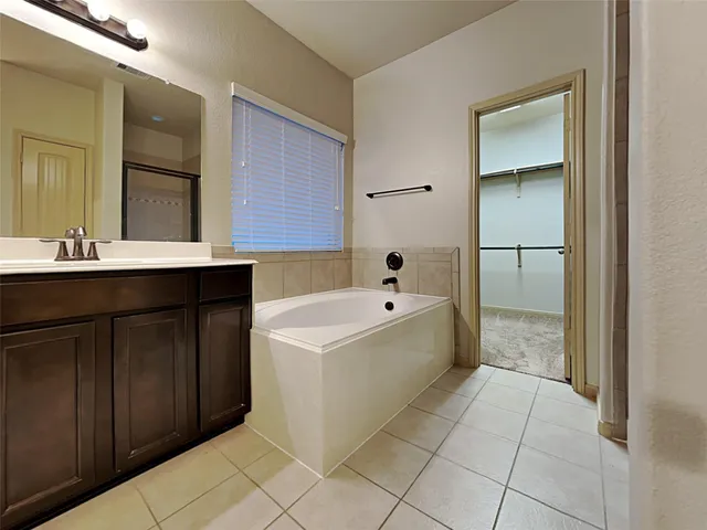 a spacious bathroom with a bathtub sink and mirror