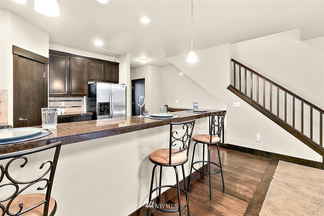 3808 Northeast 3rd Place Renton, WA 98056 - Photo 10 of 34 a kitchen with stainless steel appliances kitchen island hardwood floor and chairs