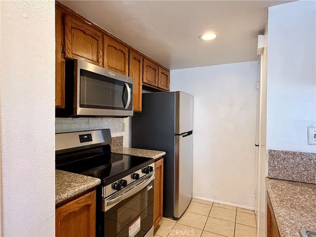 a kitchen with stainless steel appliances granite countertop a refrigerator stove and microwave