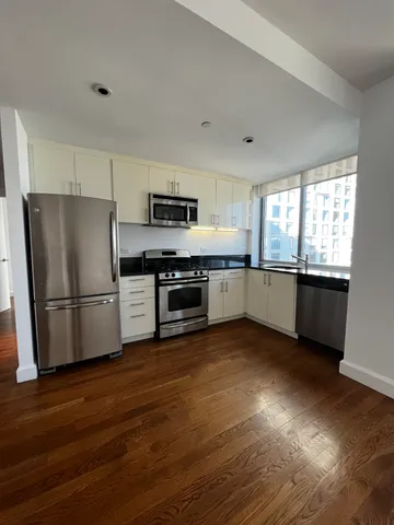 a kitchen with stainless steel appliances a stove a sink and a refrigerator