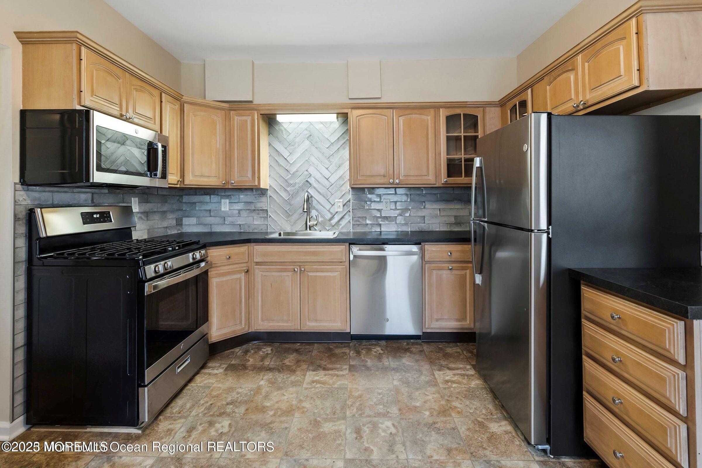 34 Bridge Avenue, Unit A Red Bank, NJ 07701 - Photo 11 of 27 a kitchen with stainless steel appliances granite countertop a refrigerator stove and microwave
