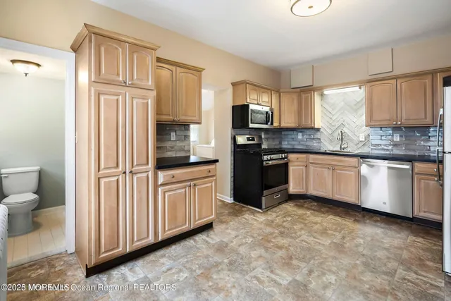 a kitchen with stainless steel appliances granite countertop a refrigerator sink and cabinets