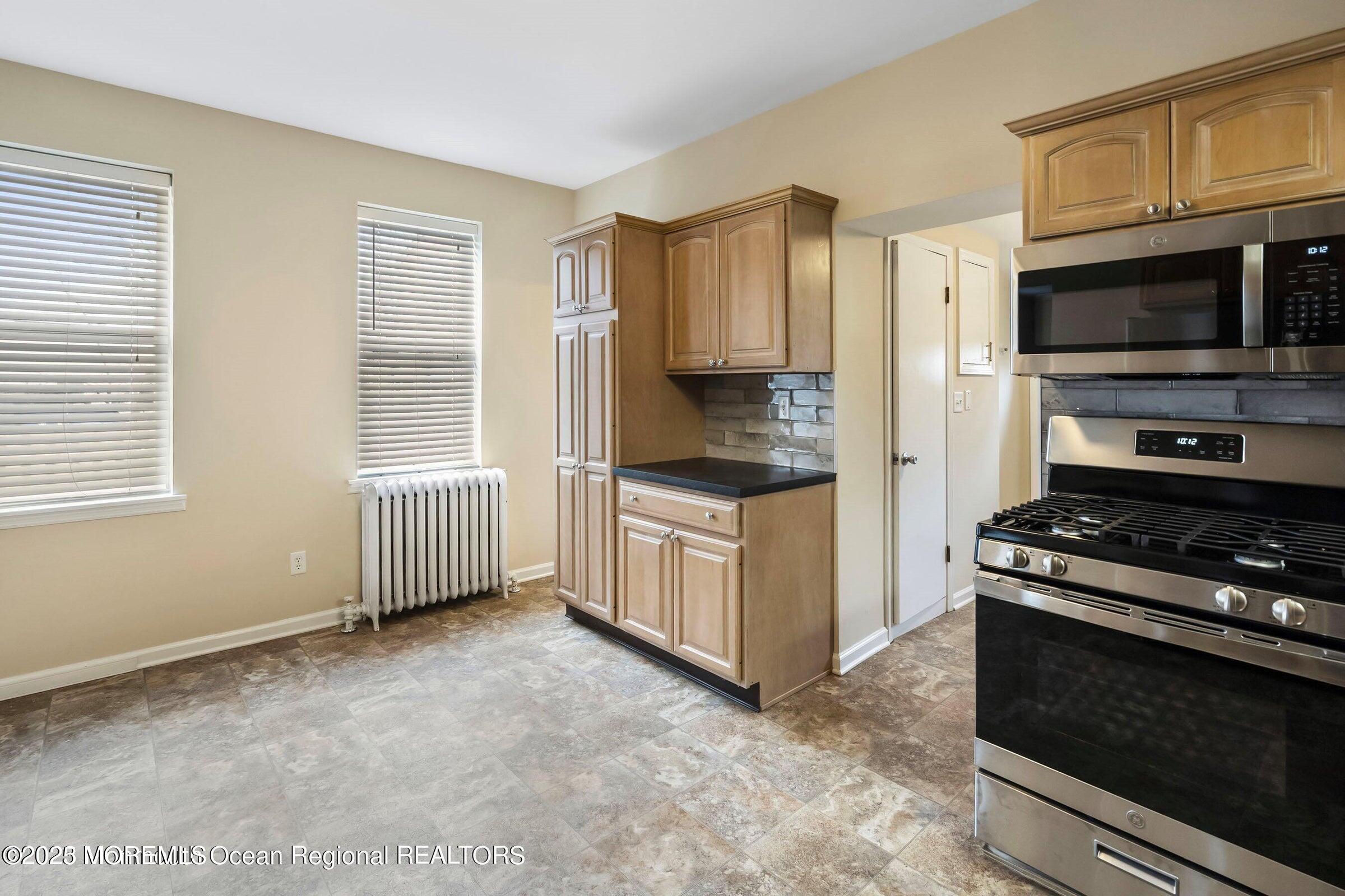 34 Bridge Avenue, Unit A Red Bank, NJ 07701 - Photo 16 of 27 a kitchen with stainless steel appliances a stove a microwave and a sink