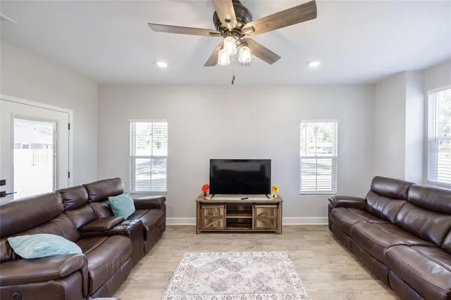 a living room with furniture flat screen tv and window