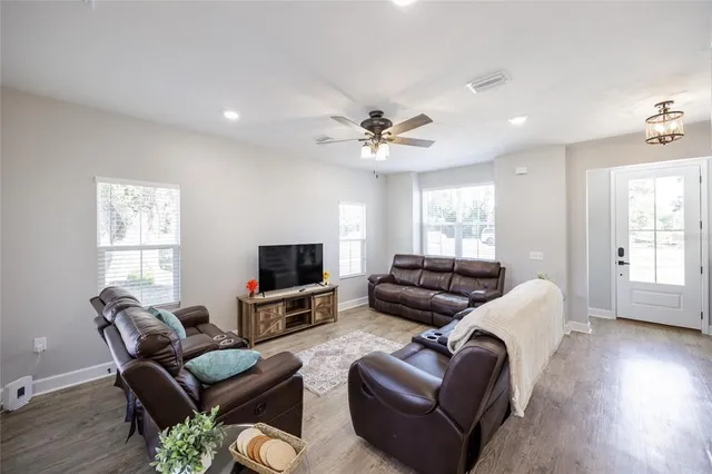 a living room with furniture ceiling fan and a window