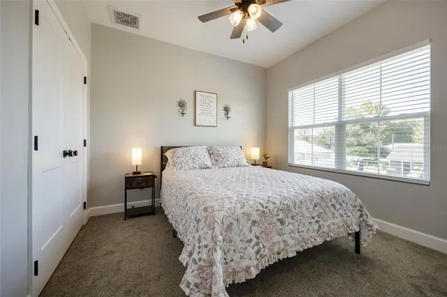 a bedroom with a bed and a large window