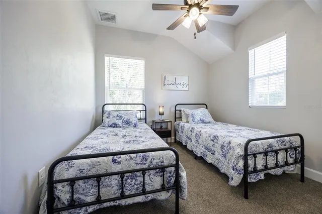 a bedroom with two beds and a chandelier