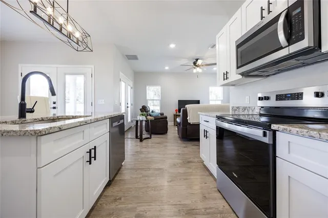 a kitchen with white cabinets and appliances