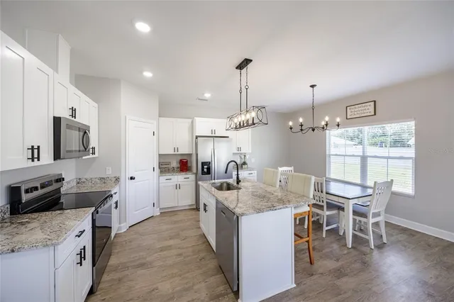 a kitchen with kitchen island granite countertop a sink counter top space appliances and cabinets