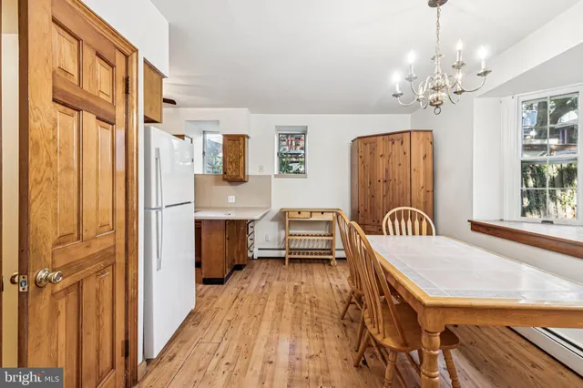 a view of a bedroom with furniture a chandelier and wooden floor
