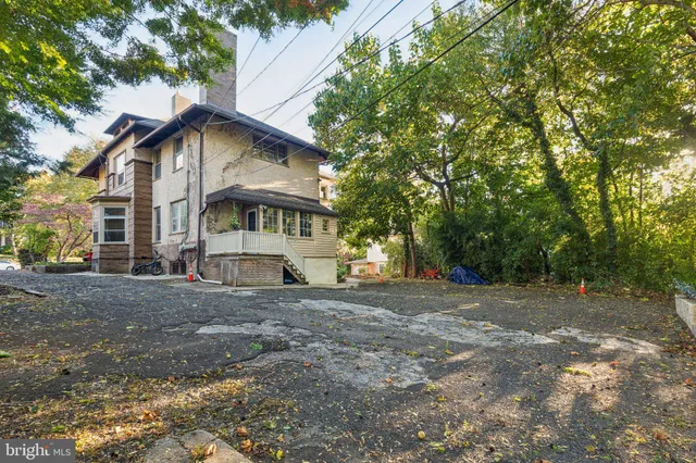 a view of large white house with a big yard and large trees
