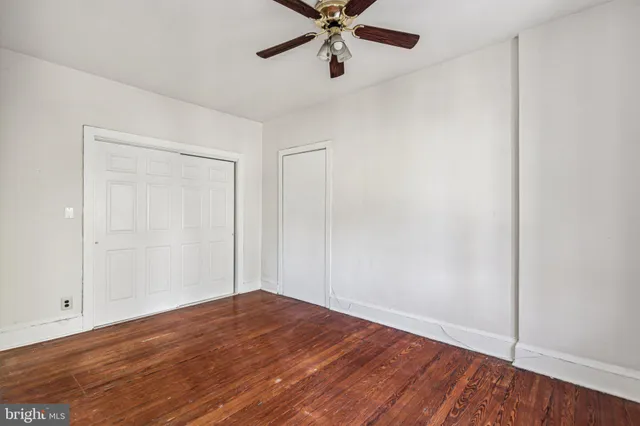 a view of a room with wooden floor and a ceiling fan