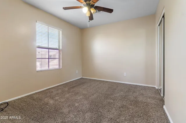 an empty room with a window and a fan