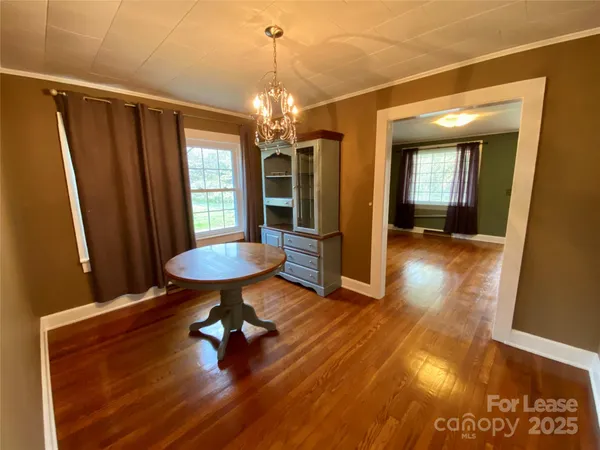 a view of a room with a chandelier and wooden floor