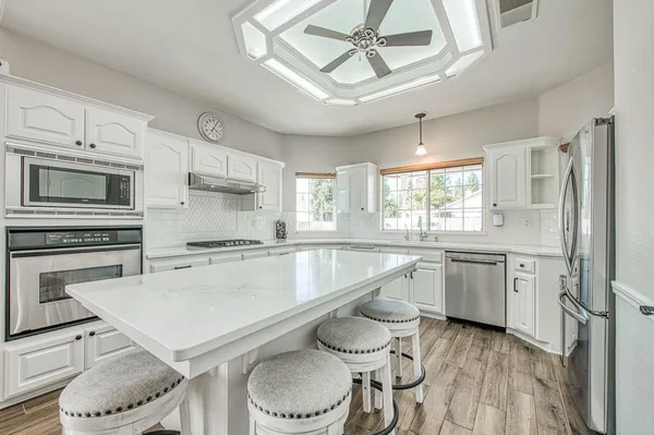 a bathroom with a sink a toilet a shower and a large mirror