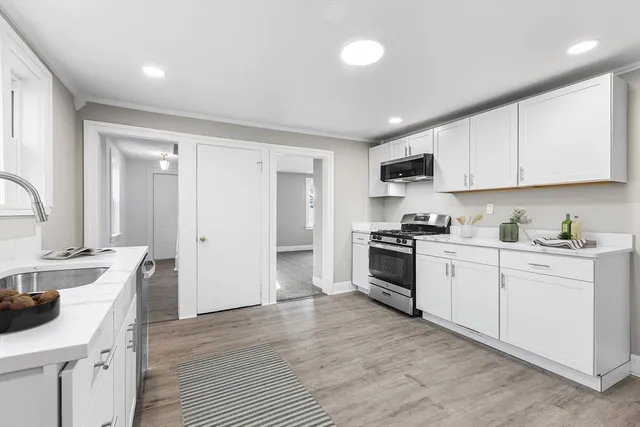 a kitchen with granite countertop white cabinets and white appliances