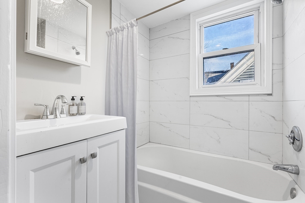 26 Pequit Street Canton, MA 02021 - Photo 7 of 8 a bathroom with a tub a sink and a window