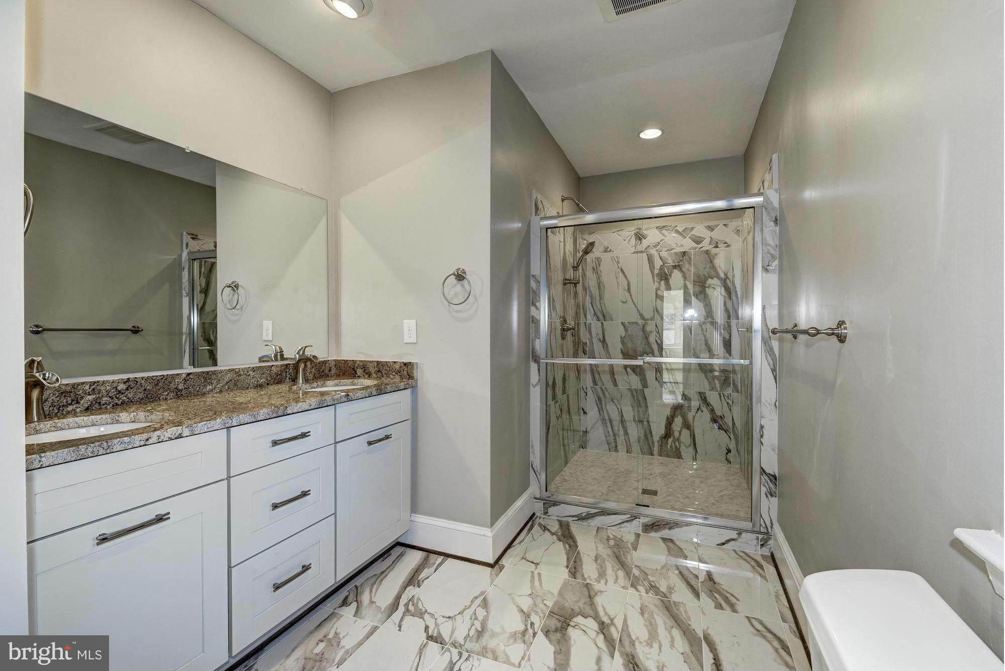 4910 Hillbrook Lane Northwest Washington, DC 20016 - Photo 17 of 30 a bathroom with a granite countertop sink toilet and shower