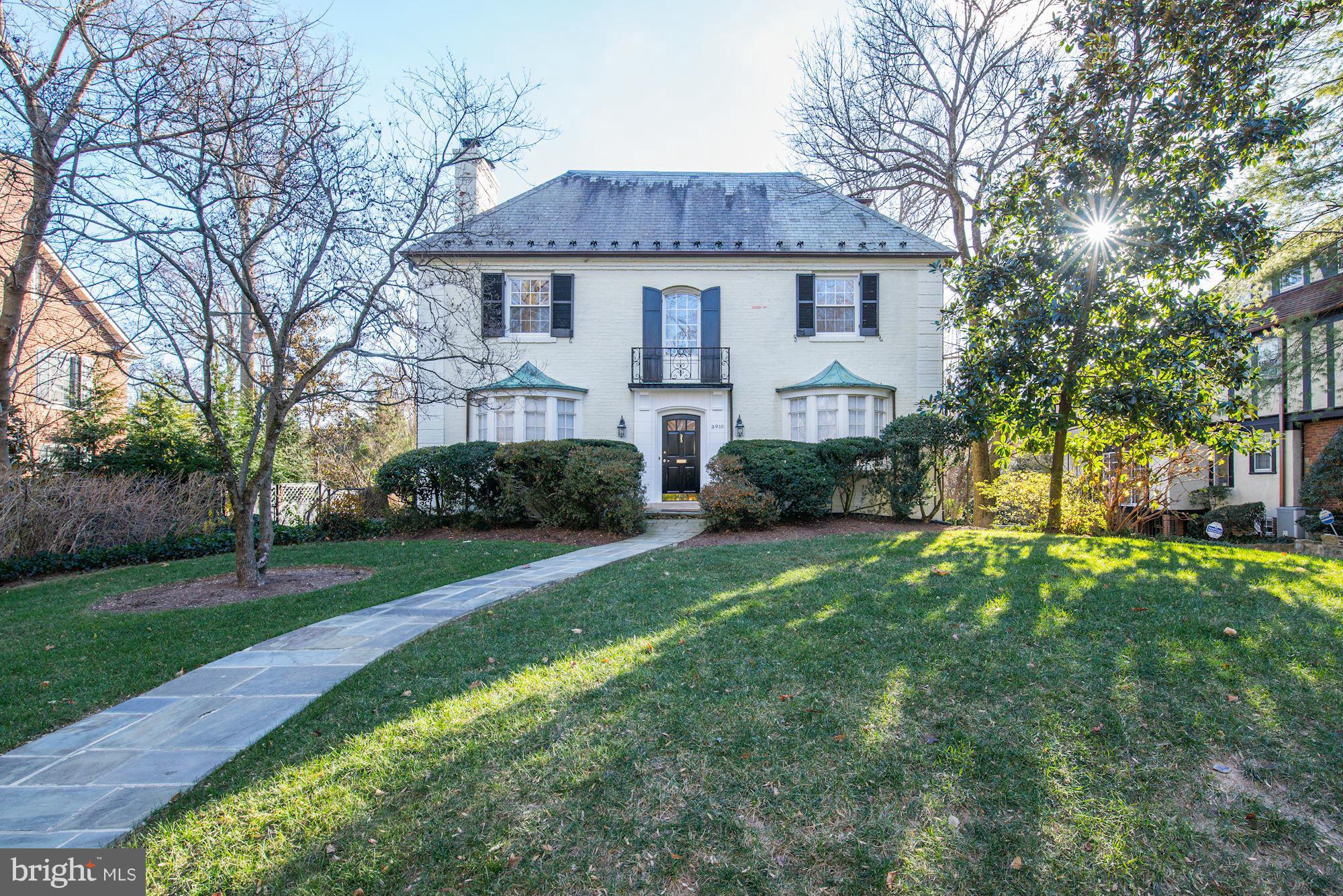 4910 Hillbrook Lane Northwest Washington, DC 20016 - Photo 2 of 30 a front view of a house with a garden and trees