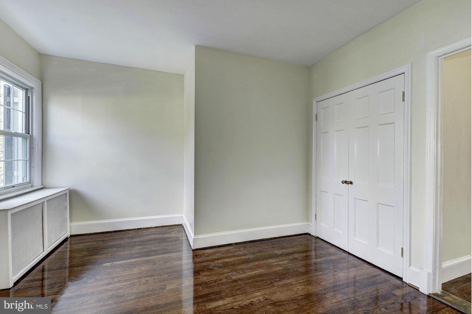 4910 Hillbrook Lane Northwest Washington, DC 20016 - Photo 21 of 30 a view of an empty room with wooden floor and a window