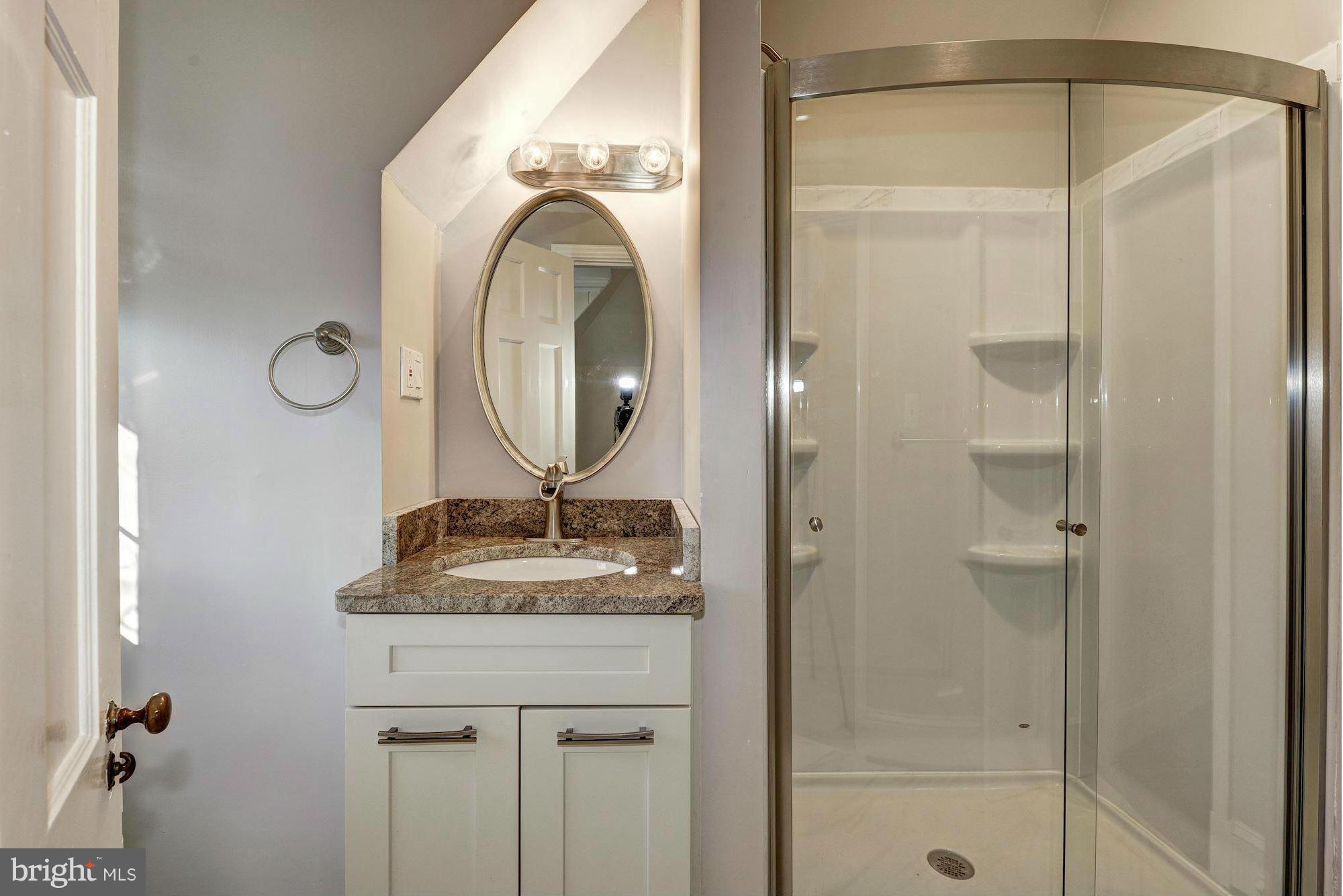 4910 Hillbrook Lane Northwest Washington, DC 20016 - Photo 24 of 30 a bathroom with a granite countertop sink a mirror and shower