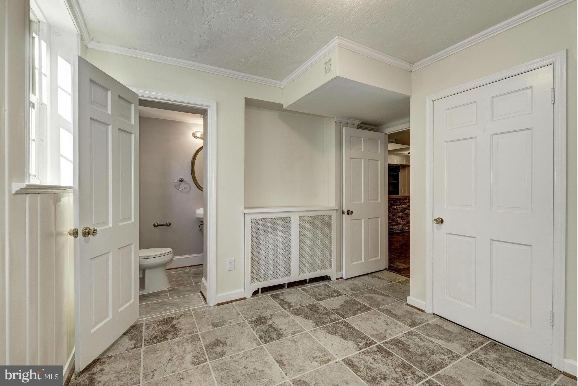 4910 Hillbrook Lane Northwest Washington, DC 20016 - Photo 26 of 30 a view of a bathroom with a walk in closet and wooden floor