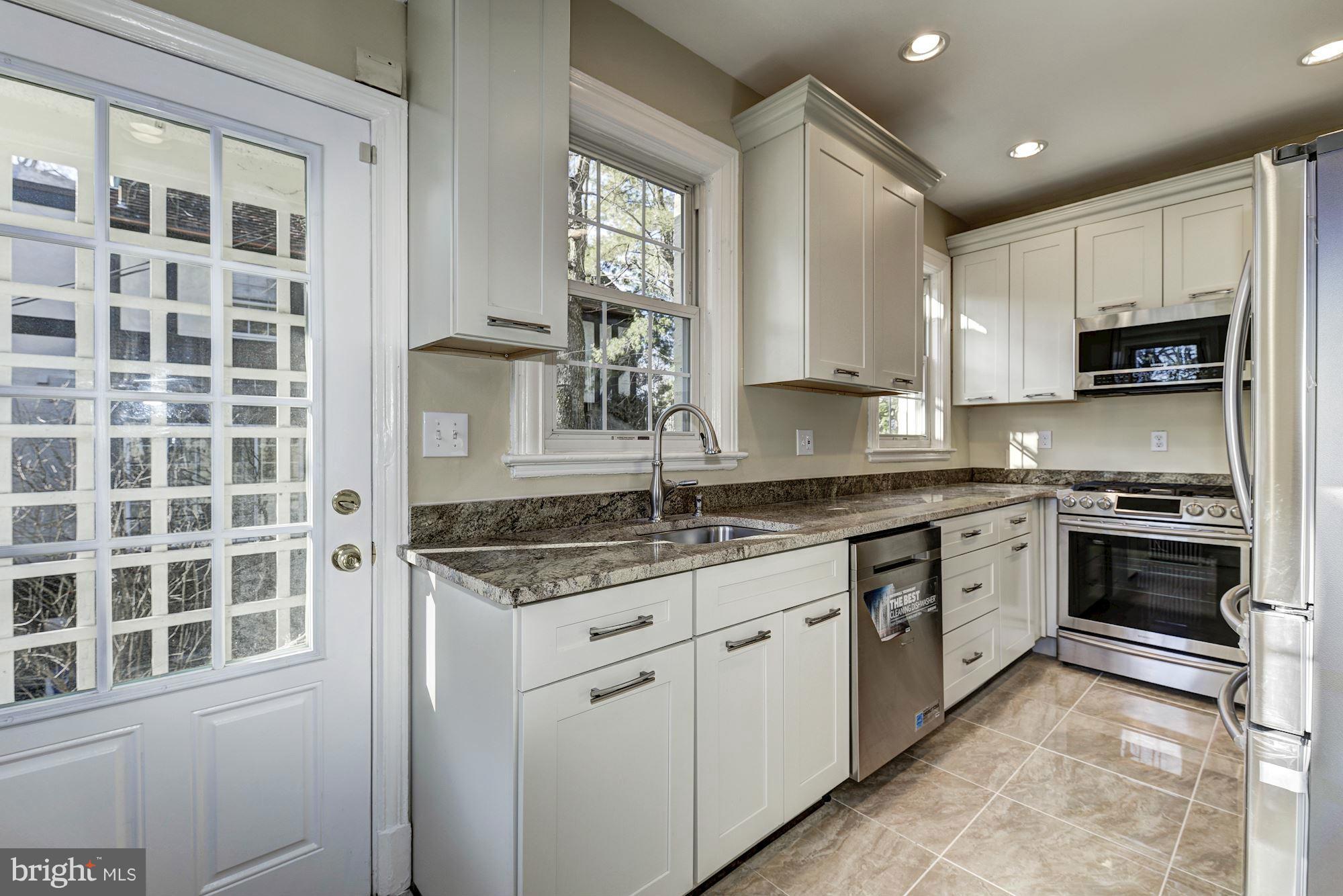 4910 Hillbrook Lane Northwest Washington, DC 20016 - Photo 9 of 30 a kitchen with granite countertop a stove a sink and a refrigerator